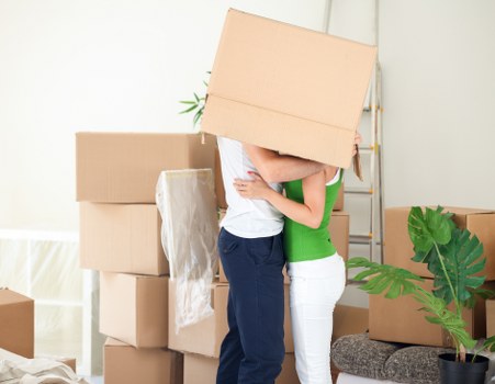Professional movers handling boxes and furniture in a West London flat